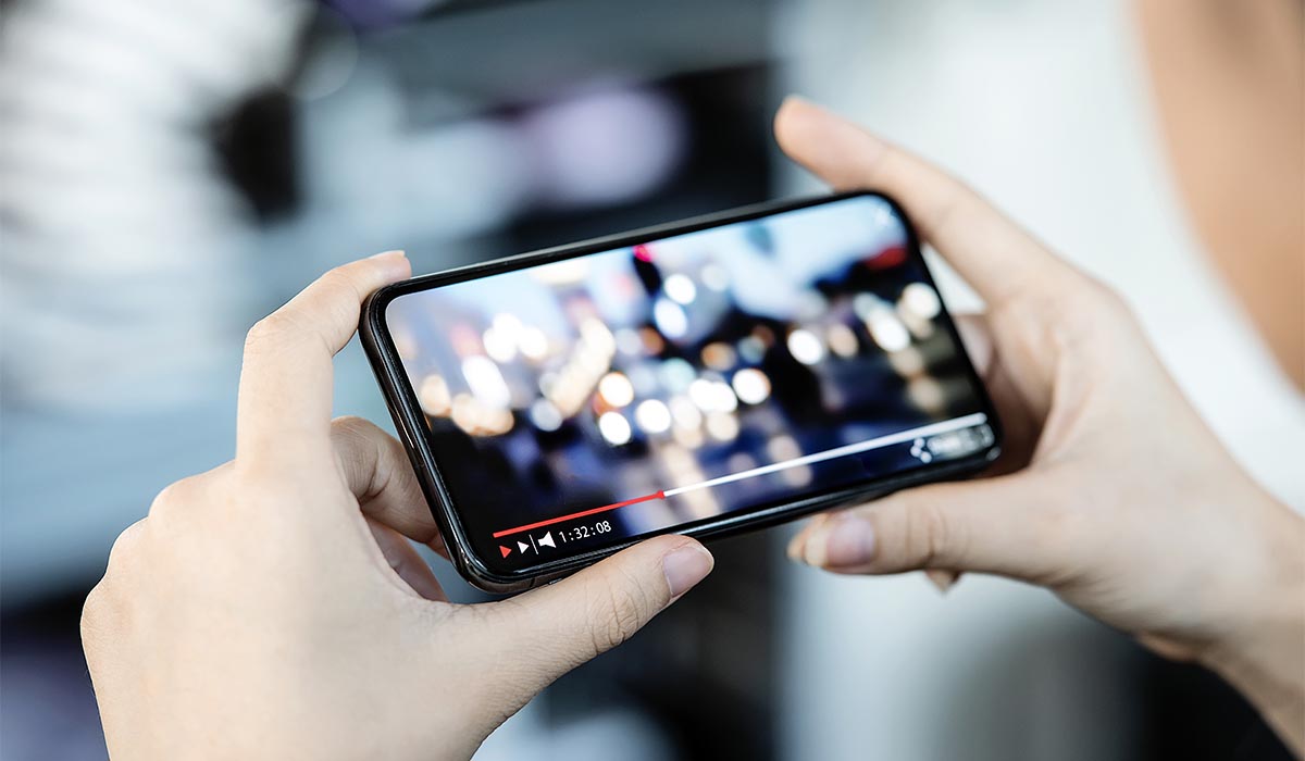 man kijkt videomarketing op smartphone